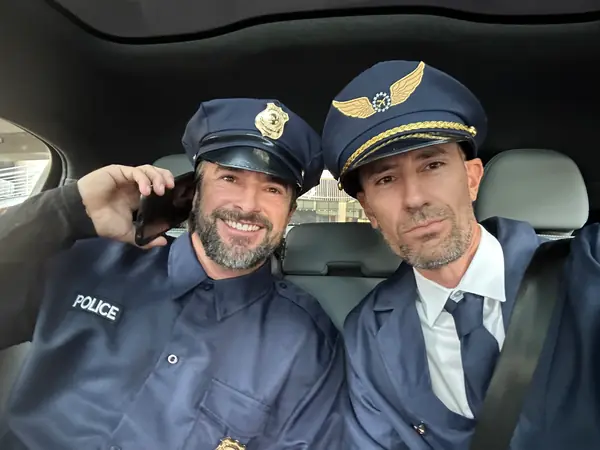 Two Encore team members in police and pilot costumes for BOMA Halloween