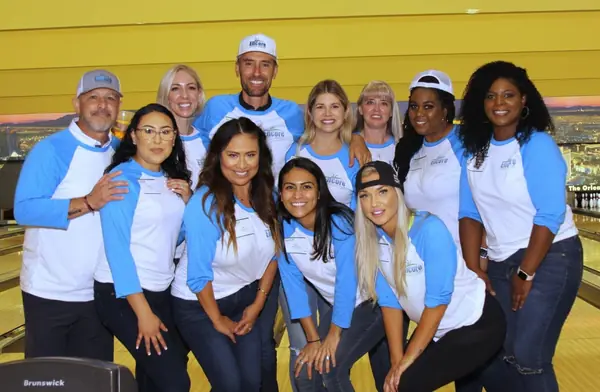 Encore team in matching blue and white shirts at a NAIOP bowling event