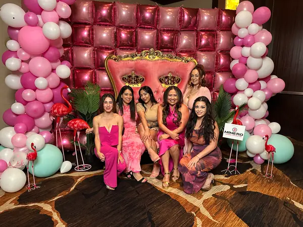 Encore guests posing on a pink balloon and throne backdrop at the NAIOP Spotlight Awards