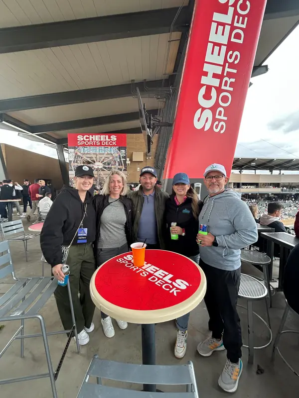 Encore team and clients at a ballpark table during a spring training game