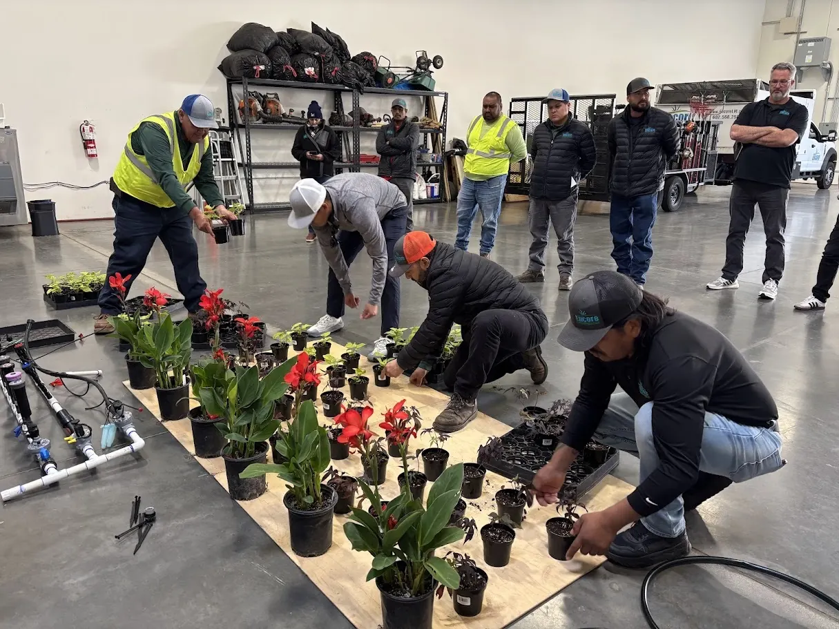 Crew practicing planting red and pink flowers during a training session in the warehouse