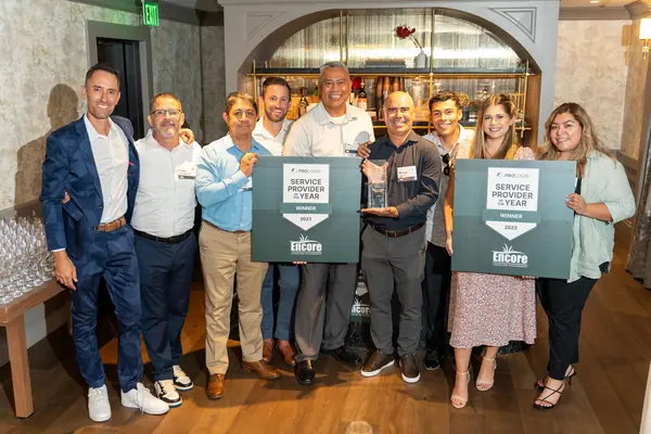 Encore team holding two Prologis Service Provider of the Year signs at the awards celebration