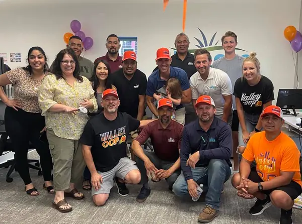 Encore office and field team posing together at an in-office celebration with balloons