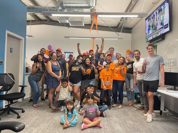 Encore employees and their kids celebrating together at an office watch party