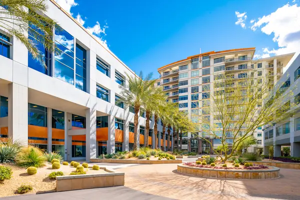 Courtyard with palms, a palo verde tree and desert shrub beds between office towers at Anchor Centre, Phoenix