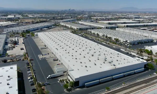 Aerial view of large warehouse buildings at Golden Triangle Industrial Park with the city skyline in the distance