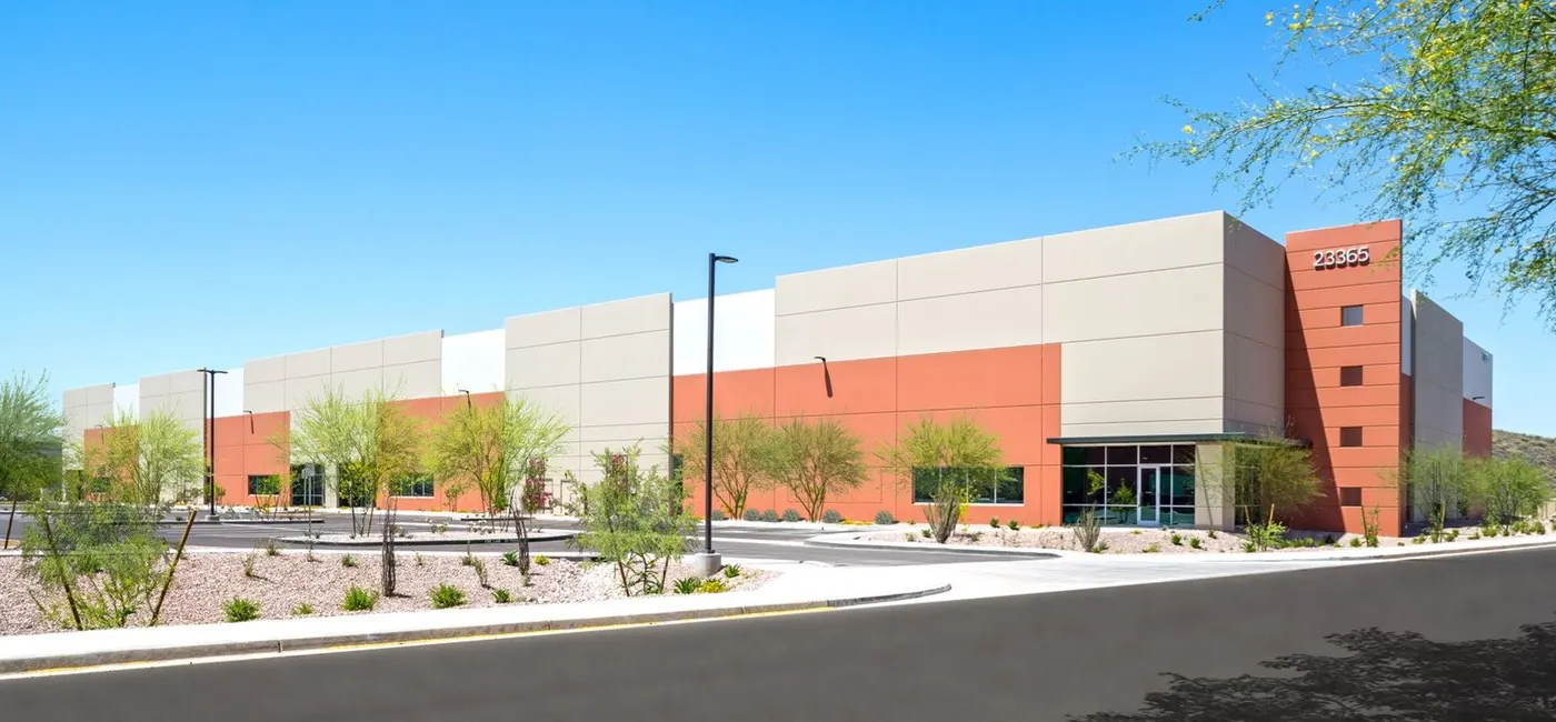 Industrial building at Prologis Corridors, Deer Valley, with young desert trees and rock landscaping along the frontage